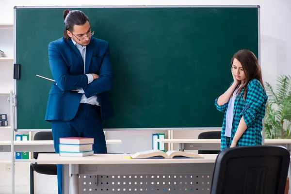 Jonge knappe leraar en vrouwelijke student in de klas — Stockfoto