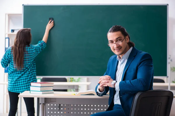 Jonge knappe leraar en vrouwelijke student in de klas — Stockfoto