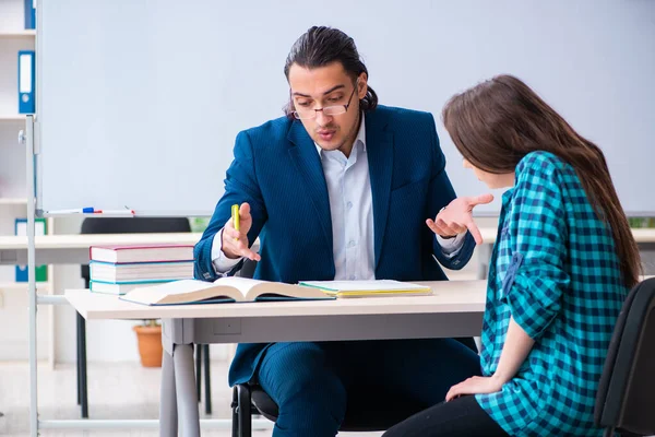 Jeune enseignant beau et étudiante dans la salle de classe — Photo