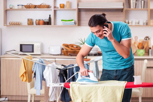 Ung man make gör kläder strykning hemma — Stockfoto