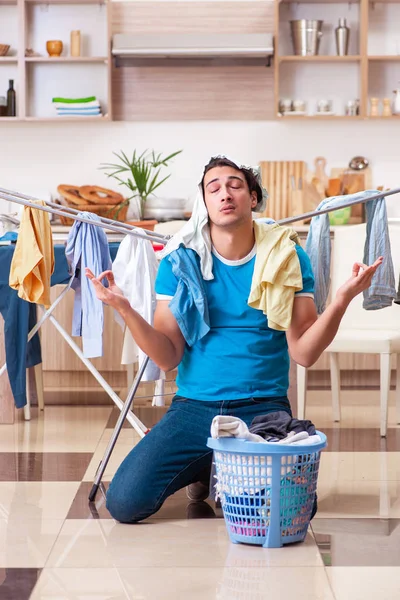 Suami muda sedang menyetrika pakaian di rumah. — Stok Foto