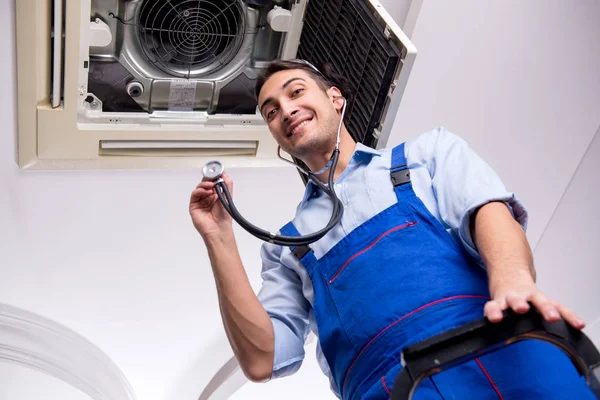 Young repairman repairing ceiling air conditioning unit — Stock Photo, Image