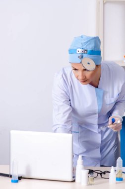 Kadın doktor otolaringolojisti ziyaret eden genç bir kadın.