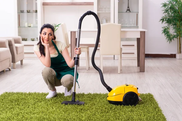 Jonge vrouwelijke aannemer doet huishoudelijk werk — Stockfoto