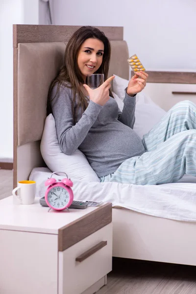 Jonge zwangere vrouw in de slaapkamer — Stockfoto