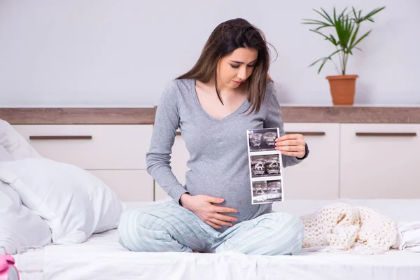 Молода вагітна жінка в спальні — стокове фото