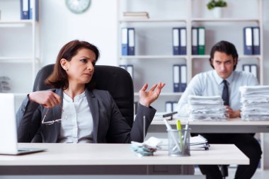 Yaşlı kadın patron ve genç erkek çalışan ofiste.