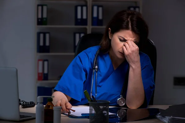 Ältere Ärztin arbeitet in der Nachtschicht — Stockfoto