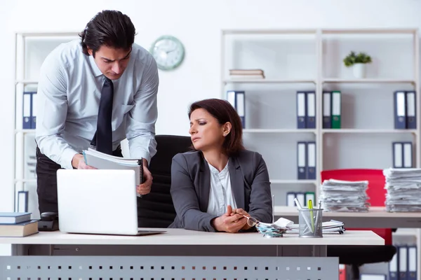 Vecchio capo femminile e giovane dipendente maschile in ufficio — Foto Stock