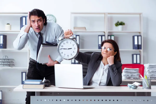 Old female boss and young male employee in the office