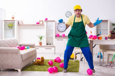 Genç erkek müteahhit partiden sonra ev işi yapıyor.