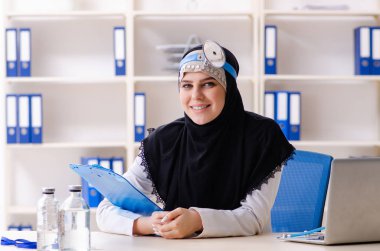Klinikte çalışan tesettürlü genç doktor.