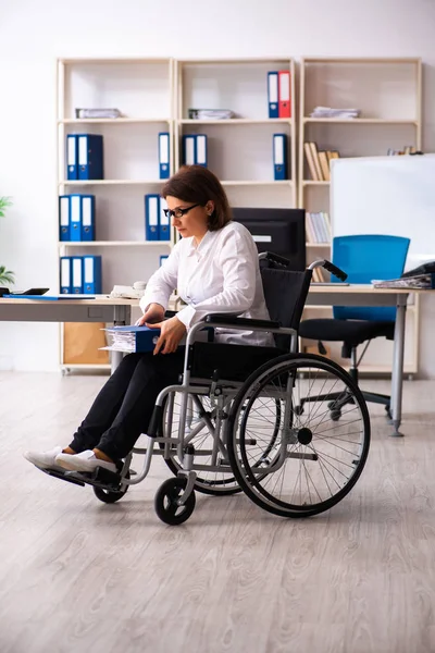 Kobieta na wózku inwalidzkim w biurze — Zdjęcie stockowe