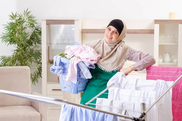 Kvinna i hijab gör kläder strykning hemma — Stockfoto