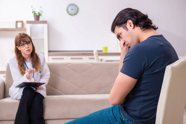 Jovem paciente do sexo masculino discutindo com psicólogo feminino pessoal — Fotografia de Stock