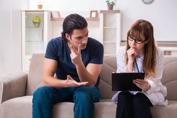 Jonge mannelijke patiënt in gesprek met vrouwelijke psycholoog persoonlijk — Stockfoto