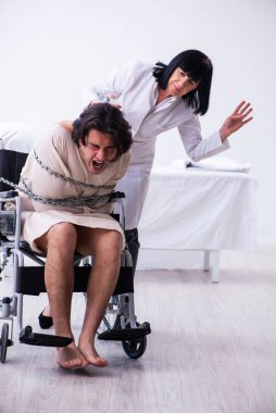 Yaşlı kadın psikiyatrist genç erkek hastayı ziyaret ediyor