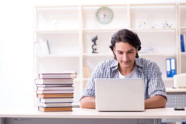 Evde sınava hazırlanan genç bir erkek öğrenci.