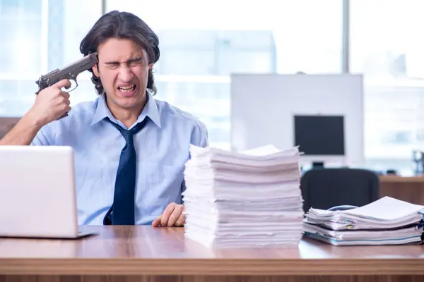 Jovem funcionário infeliz com excesso de trabalho — Fotografia de Stock