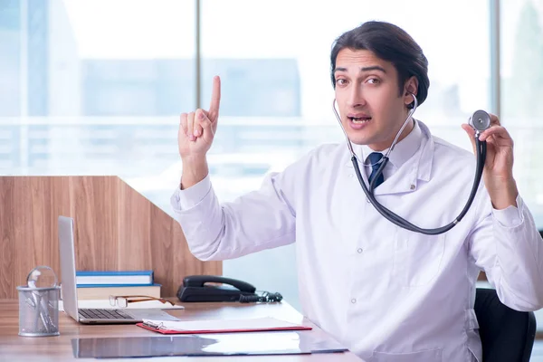 Giovane bel dottore che lavora in clinica — Foto Stock