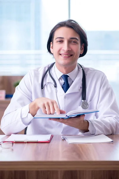 Joven médico guapo que trabaja en la clínica —  Fotos de Stock