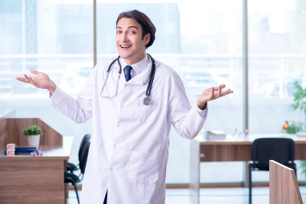 Mladý pohledný lékař pracující na klinice — Stock fotografie