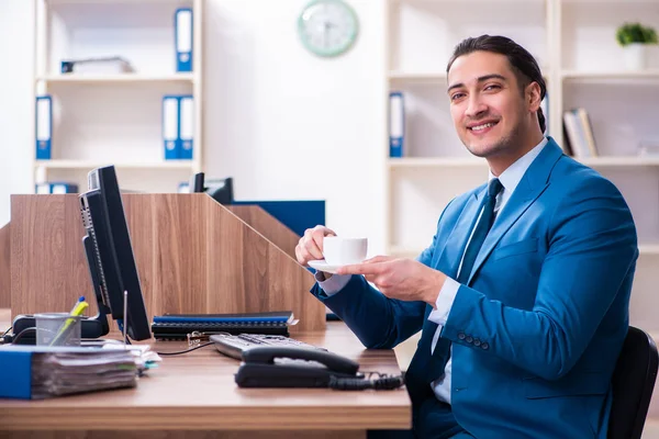 Jovem empresário bonito sentado no escritório — Fotografia de Stock