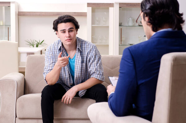 Young male patient discussing with psychologist personal problem