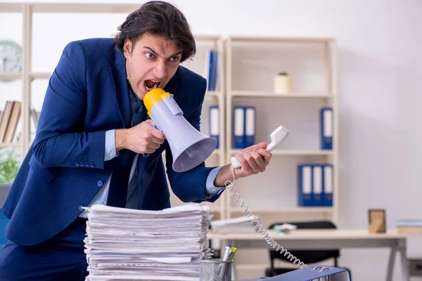 Giovane dipendente maschio infelice con il lavoro eccessivo — Foto Stock