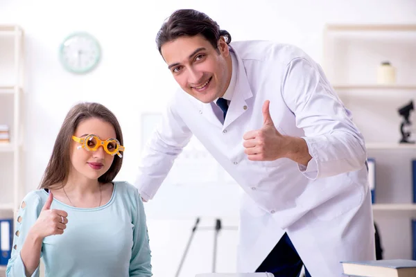 Mujer joven visitando médico oculista masculino — Foto de Stock