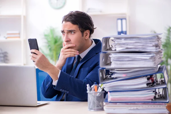 Jonge mannelijke werknemer ongelukkig met overmatig werk — Stockfoto