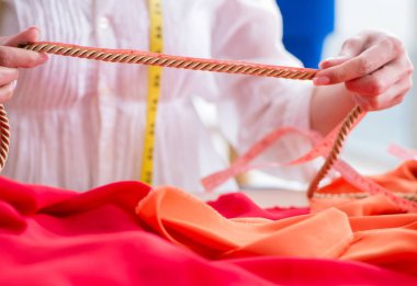 Yeni elbise tasarımları üzerinde çalışan kadın terzi.