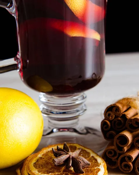Sıcak şarap, yılbaşı masasında servis edilen bardaklarda parıldıyor. — Stok fotoğraf