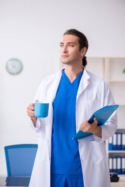 Klinikte çalışan genç erkek doktor.