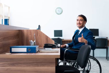 Tekerlekli sandalyede çalışan genç bir erkek.