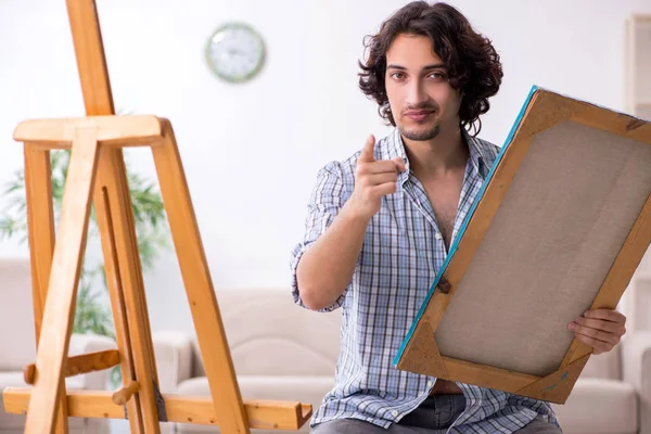 Young handsome man enjoying painting at home — Stock Photo, Image