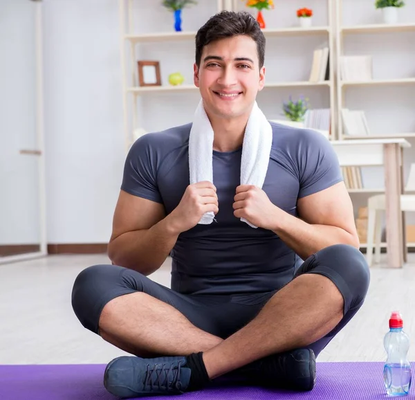 Joven haciendo ejercicio en casa en deportes y estilo de vida saludable con — Foto de Stock