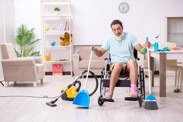 Joven en silla de ruedas limpiando la casa — Foto de Stock