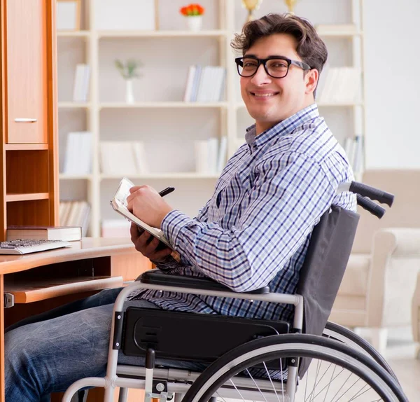 Gehandicapte student die thuis in een rolstoel studeert — Stockfoto