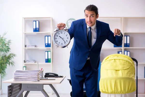 Young father looking after newborn in the office