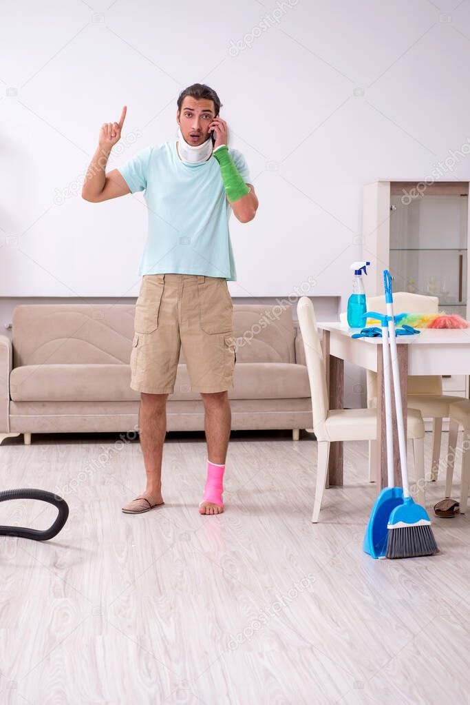 Young injured man cleaning the house