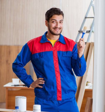 Yooung marangoz boyayla uğraşıyor.