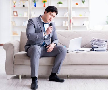 Üzgün işadamı ofiste şarkı söylüyor.