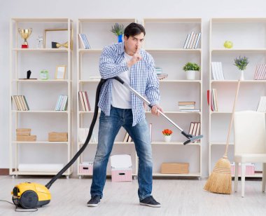 Adam evi temizliyor.