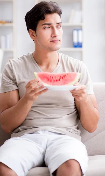 Uomo mangiare anguria a casa — Foto Stock