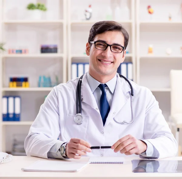 Junger Arzt sitzt im Büro — Stockfoto