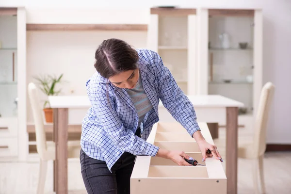 Young beautiful woman assembling furniture at home — Stock Photo, Image