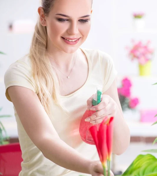 Jonge vrouw water geven planten in haar tuin — Stockfoto