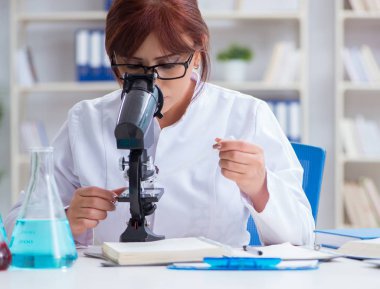 Bir laboratuarda deney yapan kadın bir bilim adamı.