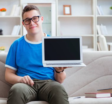 Sınavlara hazırlanan genç öğrenci kanepede ders çalışıyor.